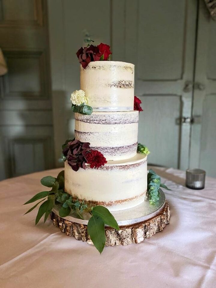 Rustic Wedding Cake with three tiers, eucalyptus and red and white flowers, in Dublin by Eve's Cakes.